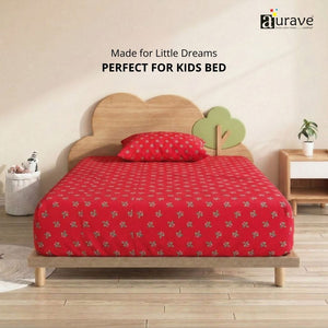 Front view of a kids wooden cloud bed dressed in a bright red 100% cotton single flat bedsheet with small green motifs by AURAVE.