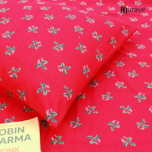 Close-up detail of a soft 210 TC pure cotton kids pillowcase and red bedsheet showing the delicate green pattern, styled with a book.