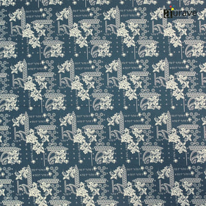 Fabric texture close-up showing the detailed white paisley and floral print on a dark teal blue cotton bedsheet.