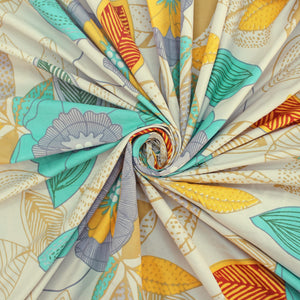 Cotton blend bedsheet fabric with teal and yellow floral print, folded swirl close-up