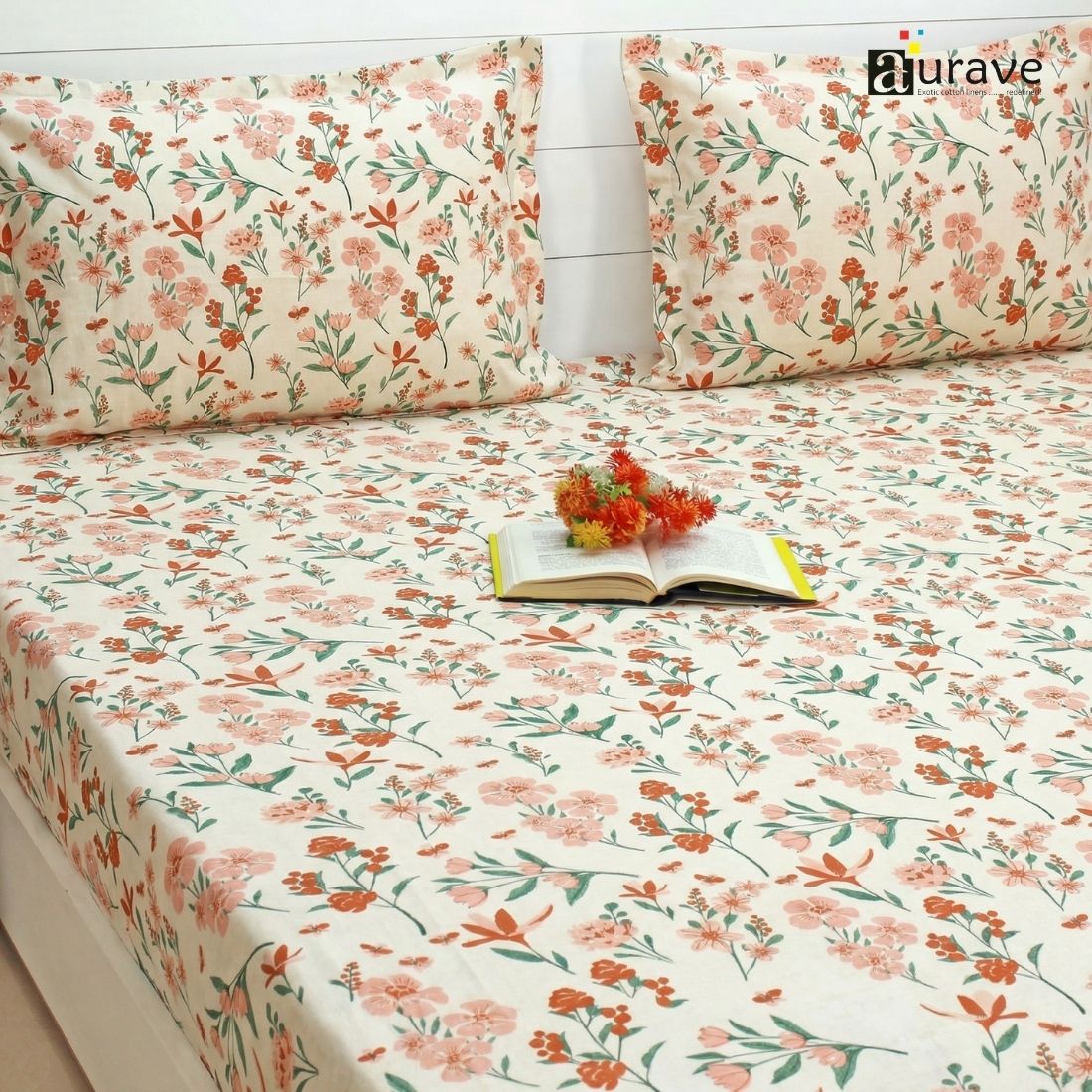 Floral patterned bedsheet with matching pillows on a bed, branded 'aurave'.