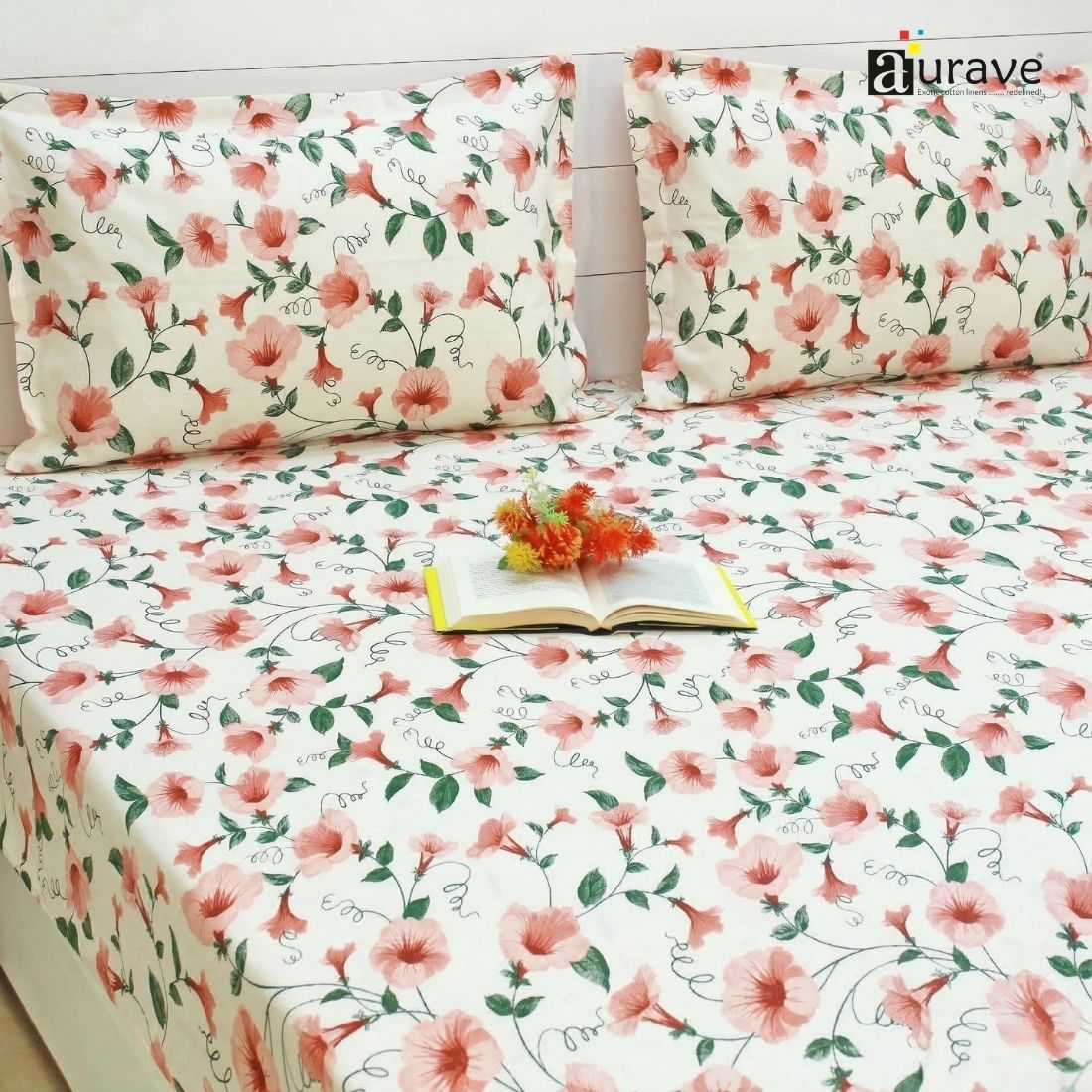 Floral patterned fitted bedsheet set with pillows on a bed, featuring the brand 'aurave'.