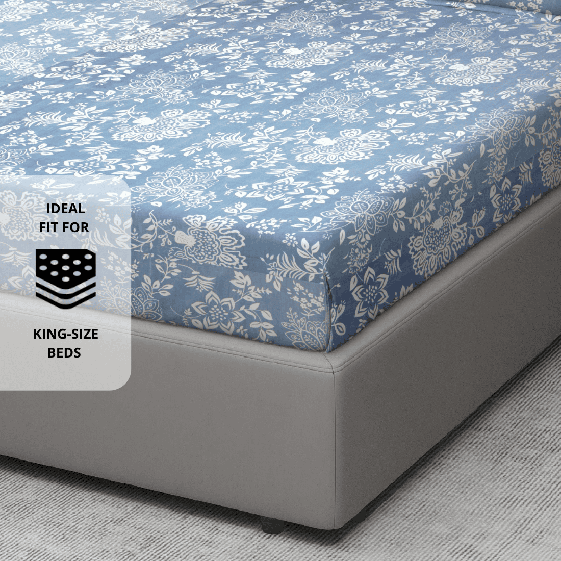 210 TC floral print cotton flat bedsheet in blue shown on a king-size bed, 