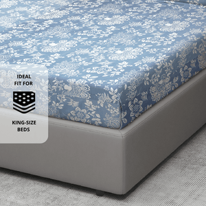 210 TC floral print cotton flat bedsheet in blue shown on a king-size bed, 