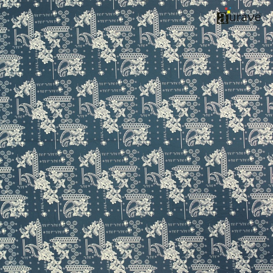 Fabric texture close-up showing the detailed white paisley and floral print on a dark teal blue cotton bedsheet.