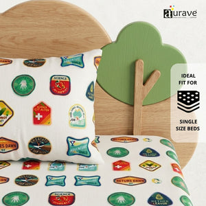 Fun kids pillow with colorful printed merit badges resting against a wooden tree and cloud headboard, featuring AURAVE pure cotton bedding.