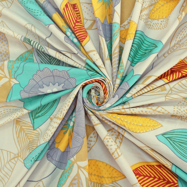 Cotton blend bedsheet fabric with teal and yellow floral print, folded swirl close-up