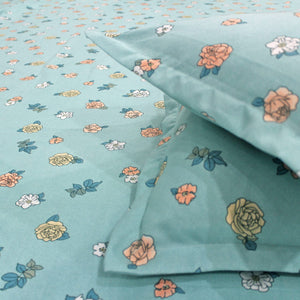 A fitted bedsheets with a floral pattern in aqua color