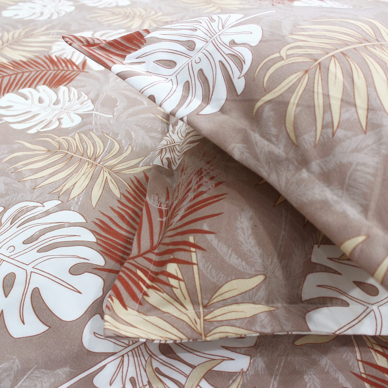 Close-up view of a floral patterned fitted bedsheets with pillow covers in brown