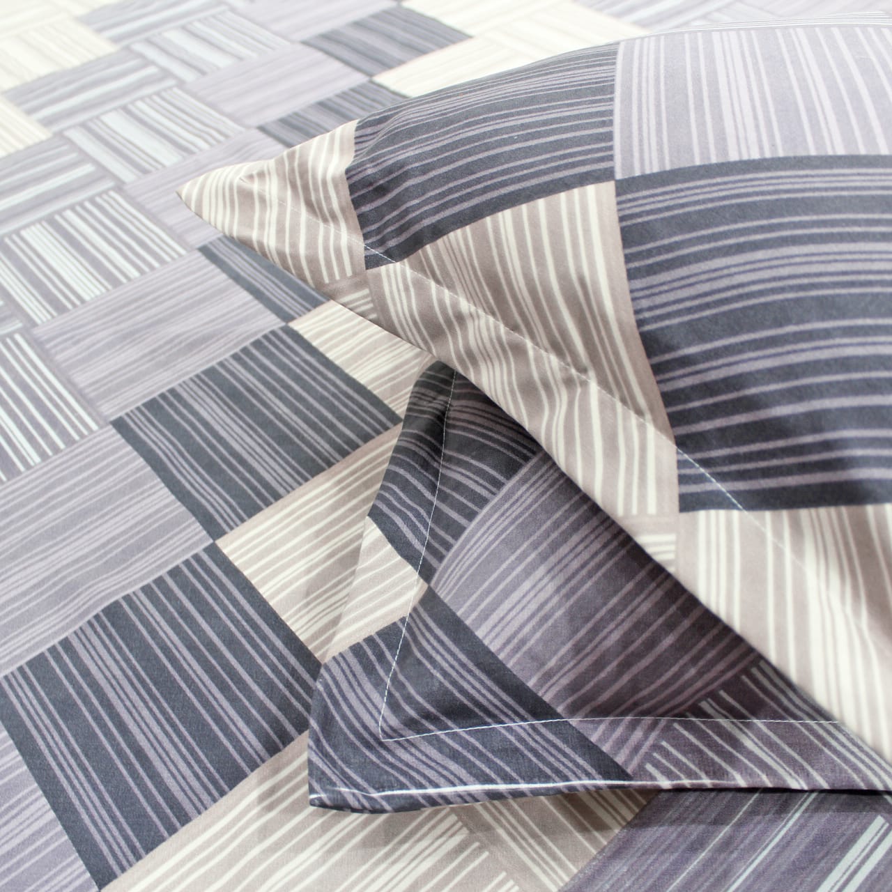 A fitted bedsheets set with a geometric pattern in purple 