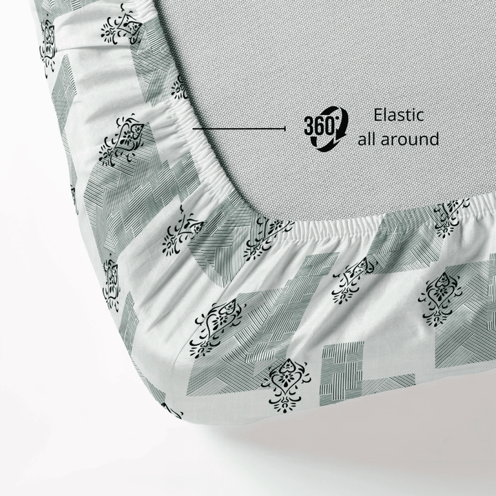 Fitted sheet with elastic all around on a mattress, showing a geometrical  pattern.