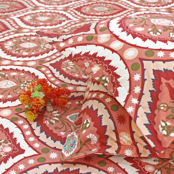 Decorative red paisley tablecloth with floral elements on a white background