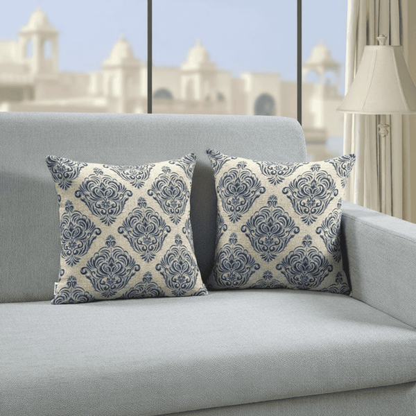 pillows with blue and white patterns on a gray sofa in a room with a cityscape view.
