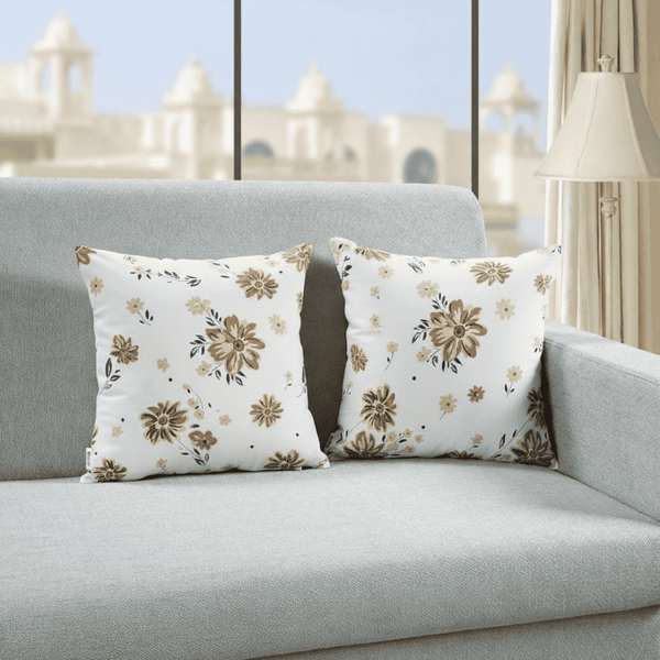 Floral patterned pillows on a gray sofa with a blurred outdoor background