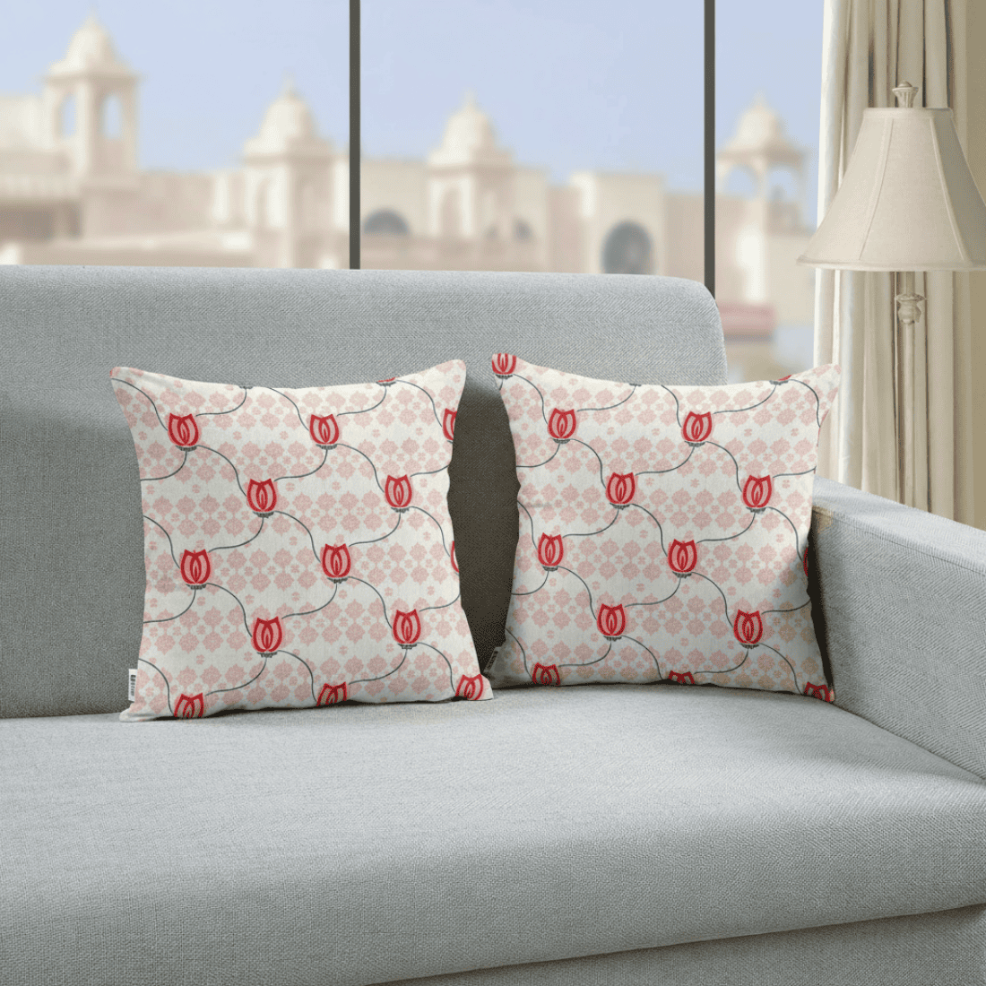 Two patterned pillows on a gray sofa with a cityscape in the background