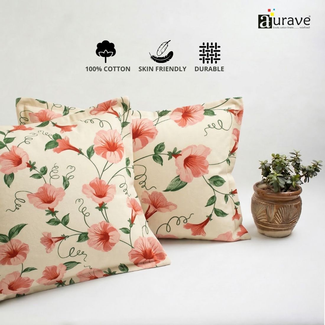 Neatly stacked AURAVE cotton pillow covers showcasing a vibrant pink floral and vine design.