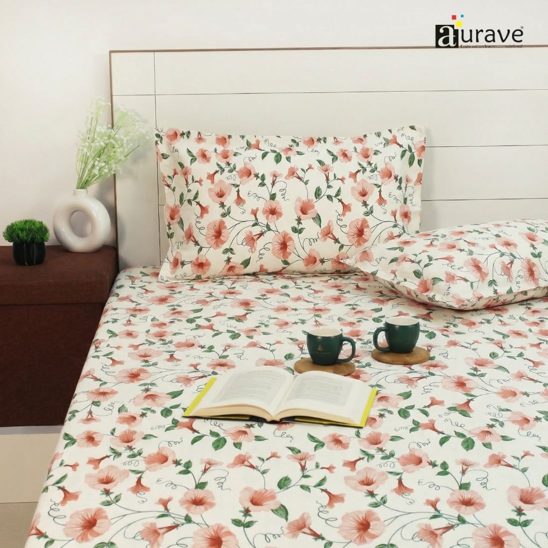 Floral patterned fitted bedsheet set with pillows on a bed, featuring the brand 'aurave'.