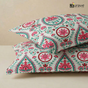 Close-up of AURAVE cotton fabric pattern featuring a traditional block-print style design with pink lotus and teal paisley motifs.