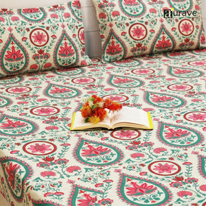 Floral patterned fitted bedspread  and flowers design on a bed, branded 'AURAVE'.