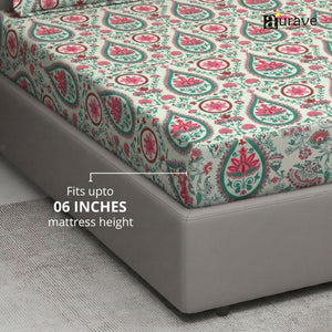 Patterned fitted bedsheet on a bed with 'AURAVE' branding and 06 inches mattress height compatibility.