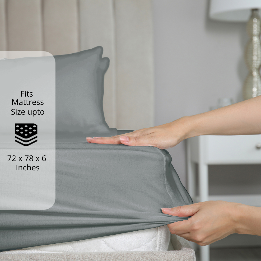 Grey fitted bedsheet being stretched over mattress corner with size label showing fits mattress size up to 72 x 78 x 6 inches.  